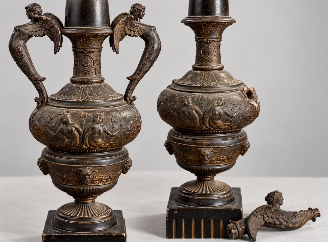 Pair of figural neoclassical table lamps, one with a detached winged handle
